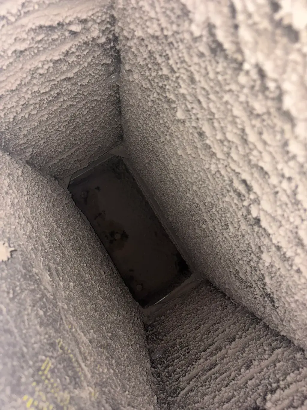 The inside of a duct lined with dust before cleaning
