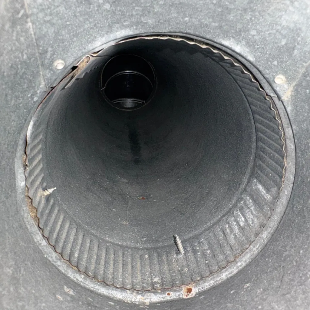 Air duct cleaning in Middletown, NY: example job photo of a round branch duct after cleaning