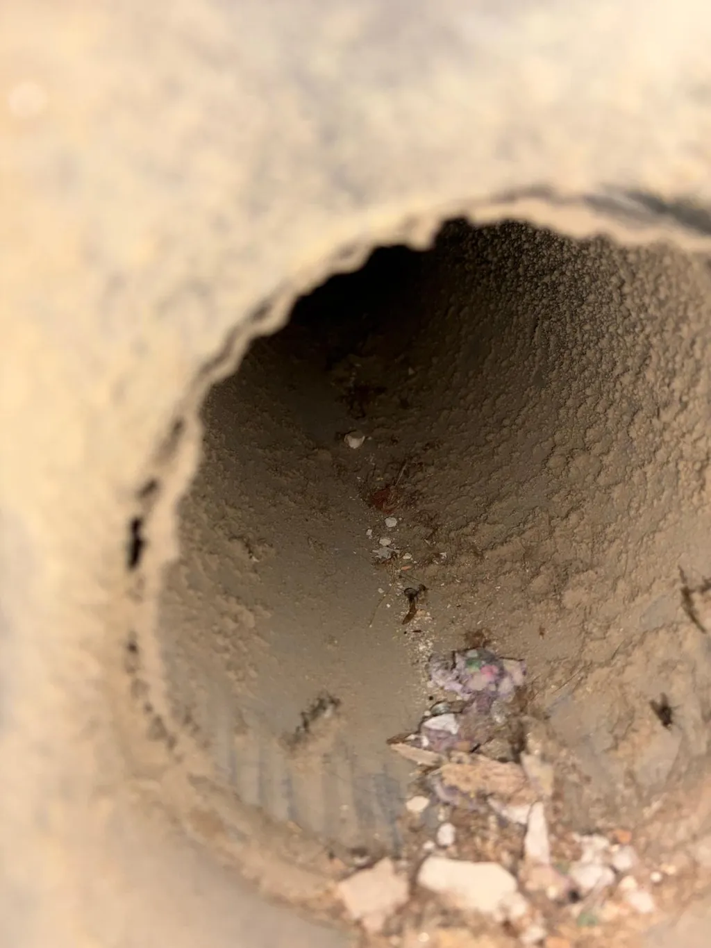 A round duct collar with dust and debris before cleaning
