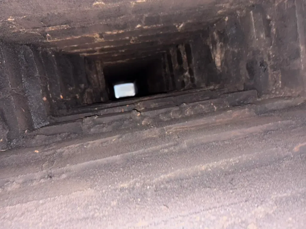 Inside a main supply duct coated in dust before cleaning