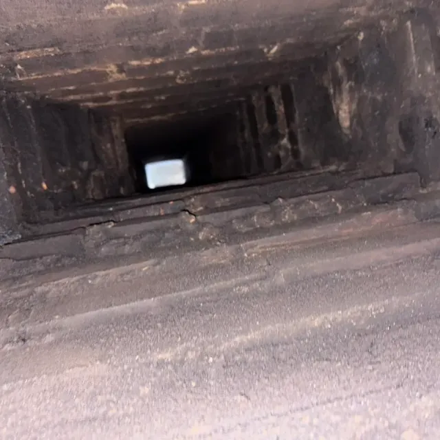 Inside a main supply duct coated in dust before cleaning