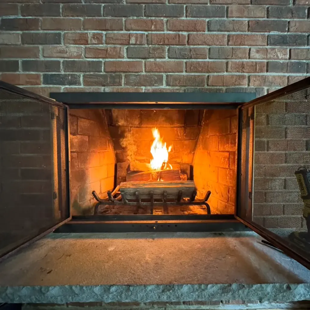 Open brick fireplace with a fire burning