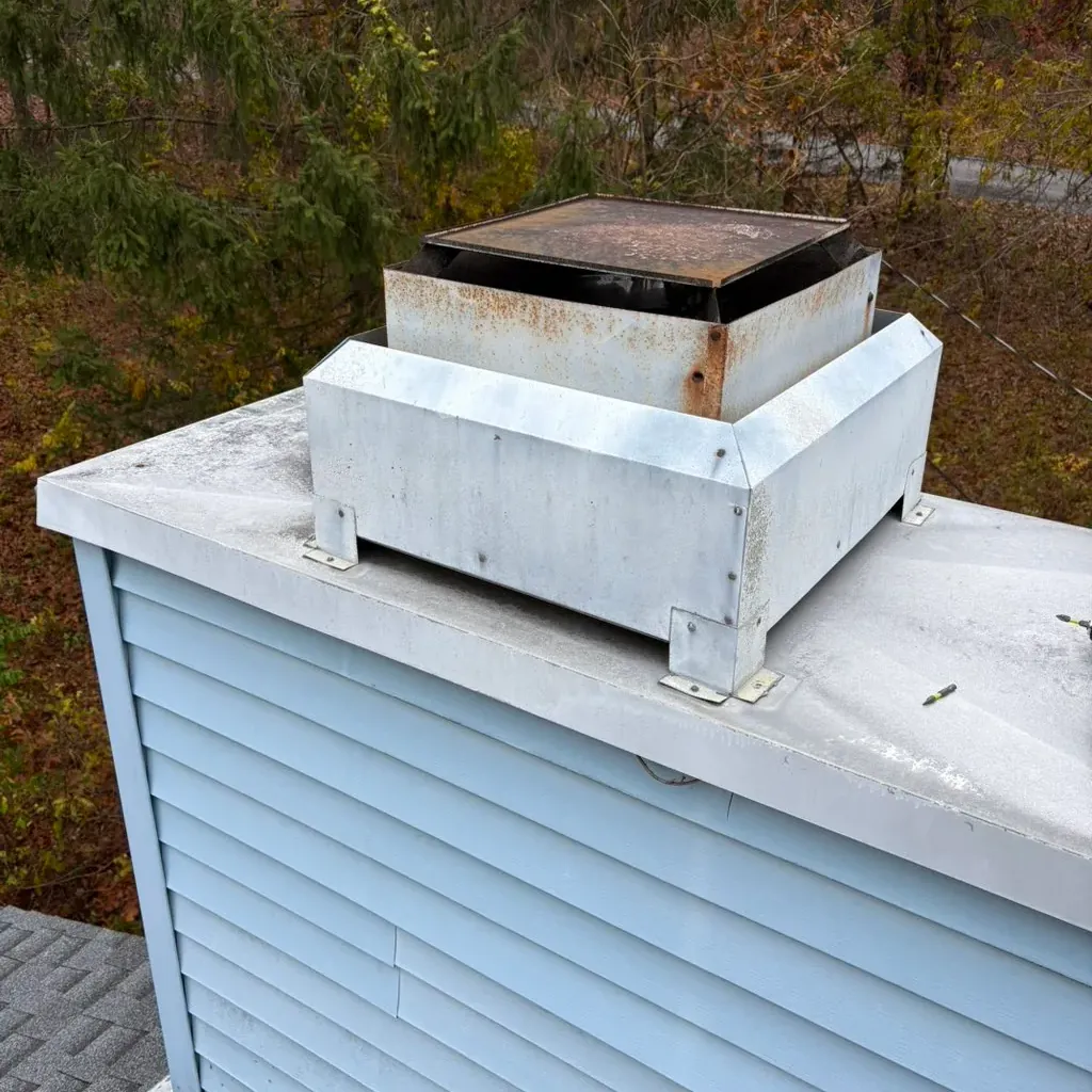 Metal chase cover on top of a sided chimney chase