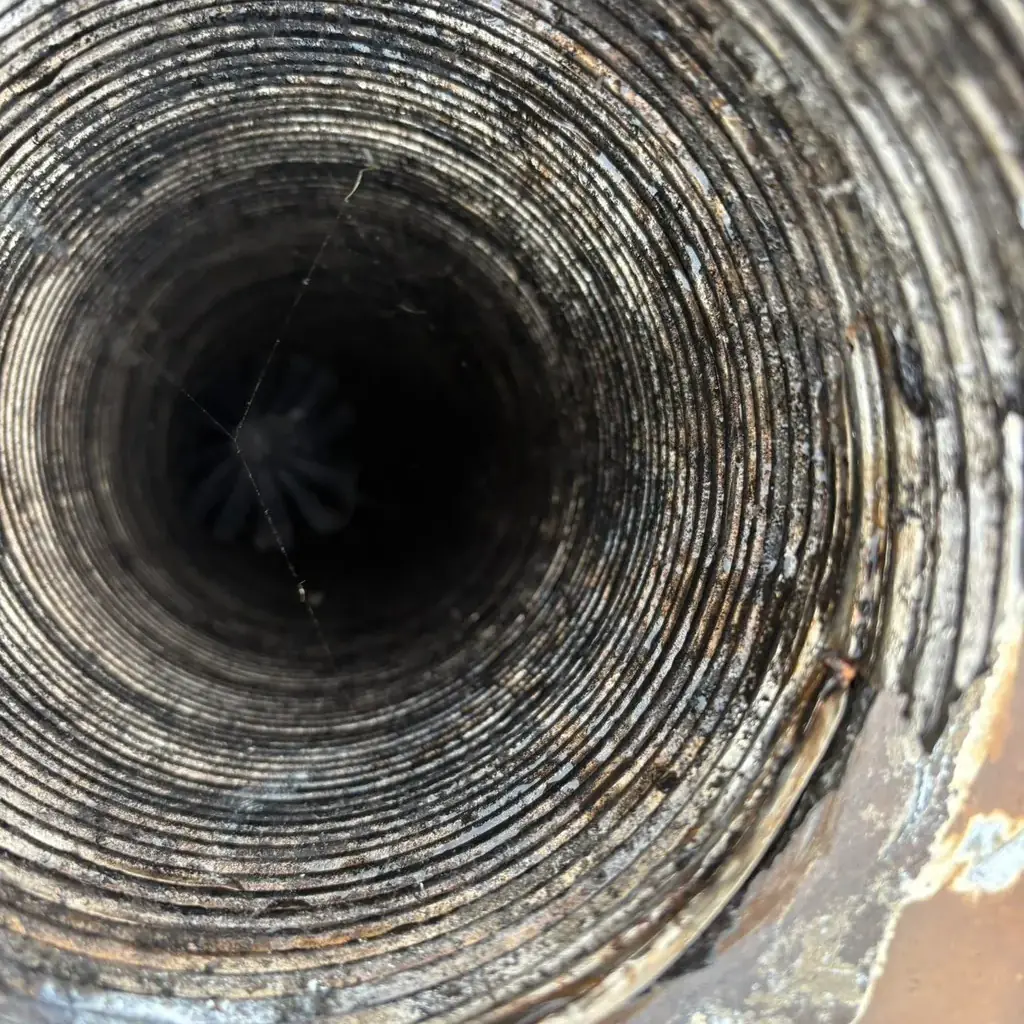 Looking down a metal chimney liner during a sweep