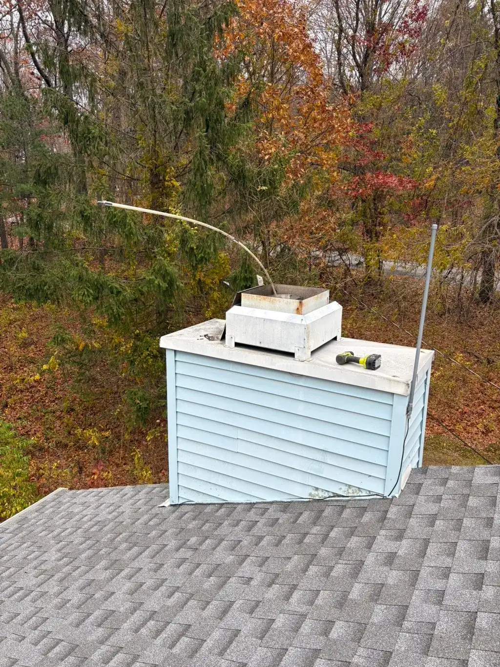 Chimney chase and cap on a shingle roof, inspected from above
