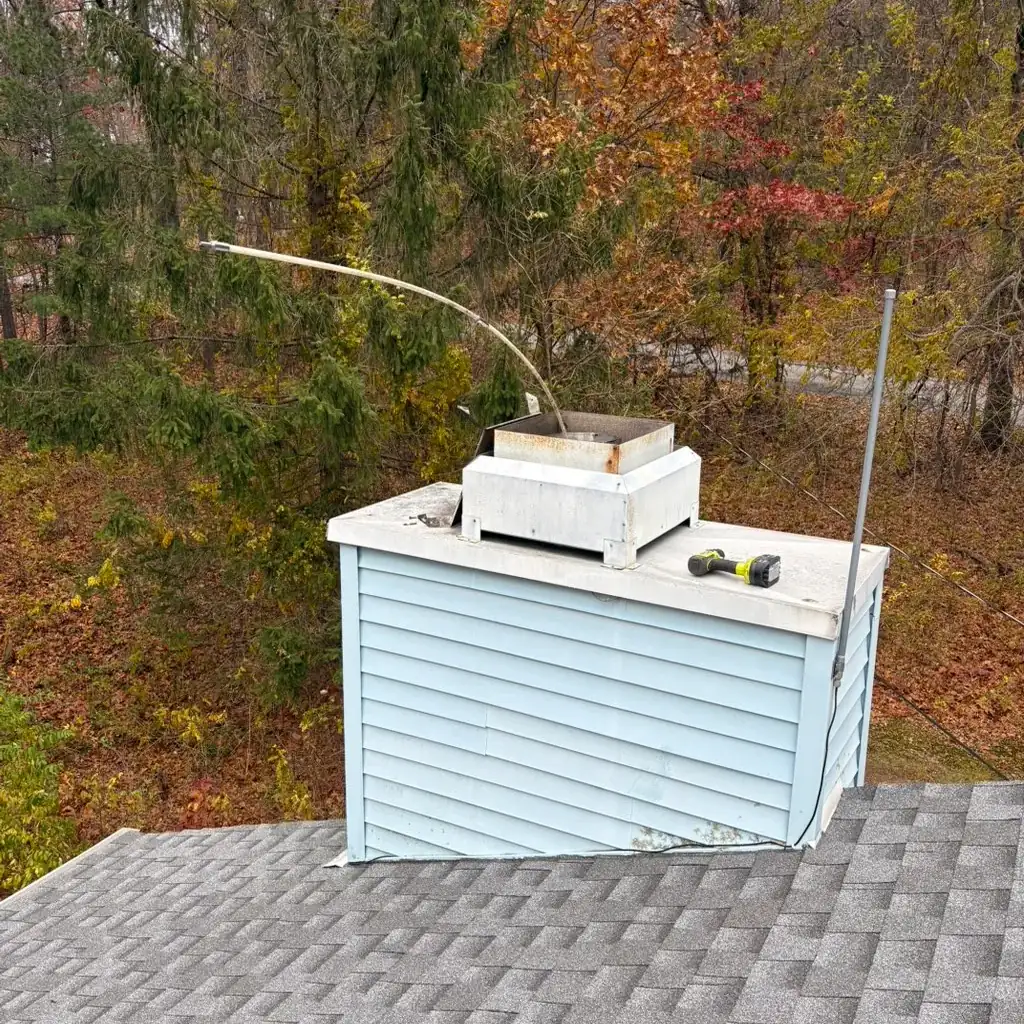 Chimney chase and cap on a shingle roof, inspected from above