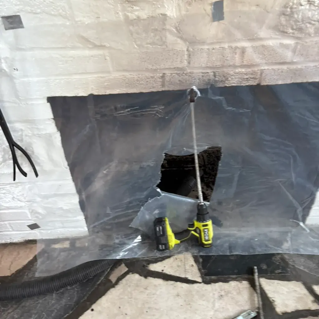 Fireplace opening sealed with sheeting before the rotary rod goes up the flue