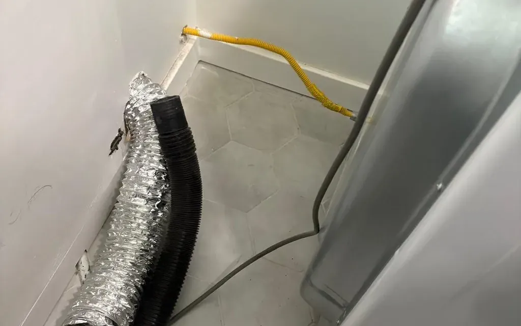 Dryer pulled out and the transition hose disconnected for a dryer vent cleaning