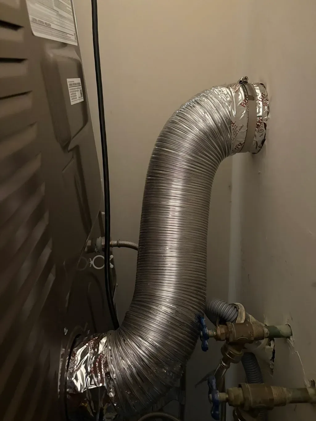 New rigid metal dryer duct installed and routed behind the machine