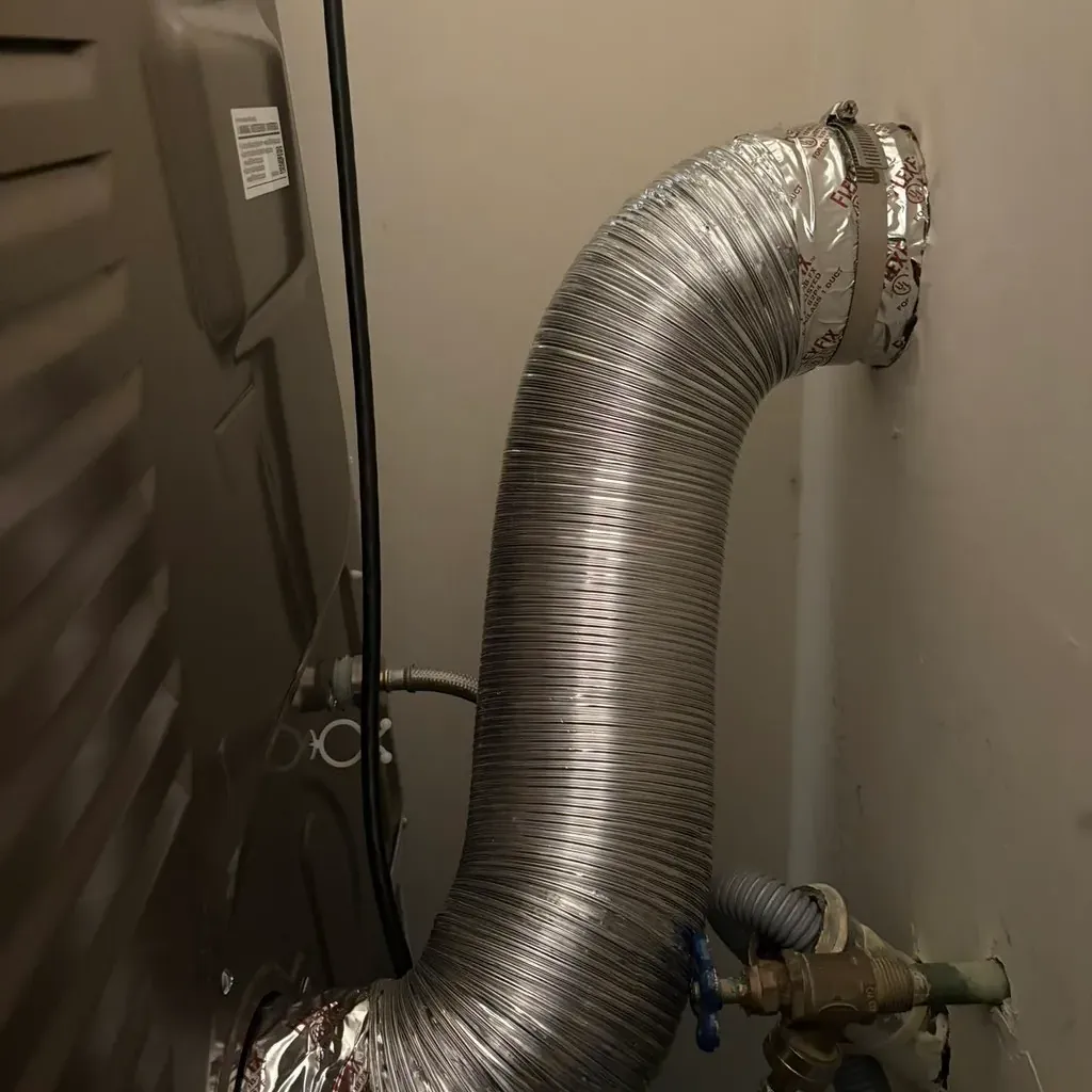 New rigid metal dryer duct installed and routed behind the machine