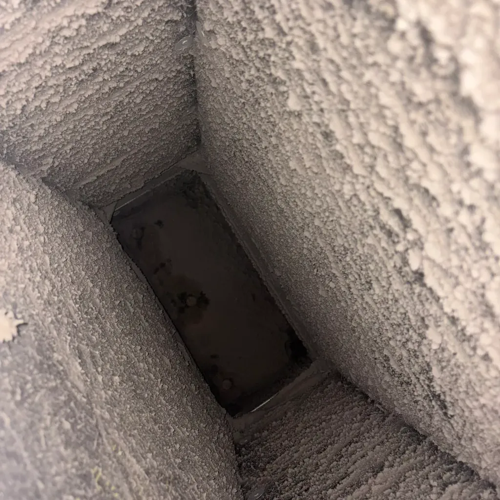 Air duct cleaning: the inside of a duct lined with dust before cleaning