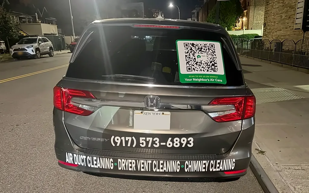 The back of Your Neighbor's Air Care's grey minivan, lettered with the phone number and Air Duct Cleaning, Dryer Vent Cleaning, Chimney Cleaning, with a Google QR code sticker in the back window
